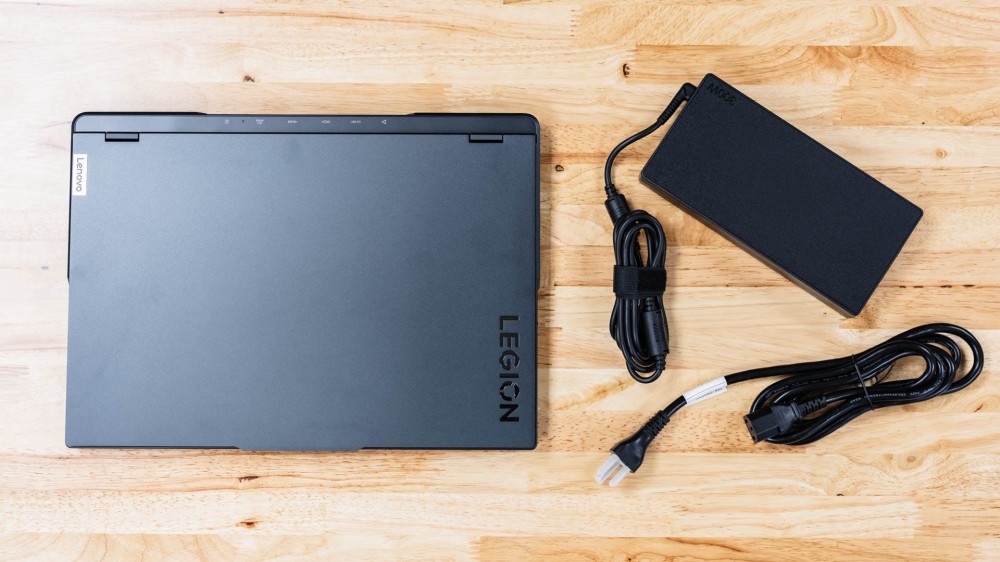 The Lenovo Legion Pro 5i Gen 8 laid next to its charger