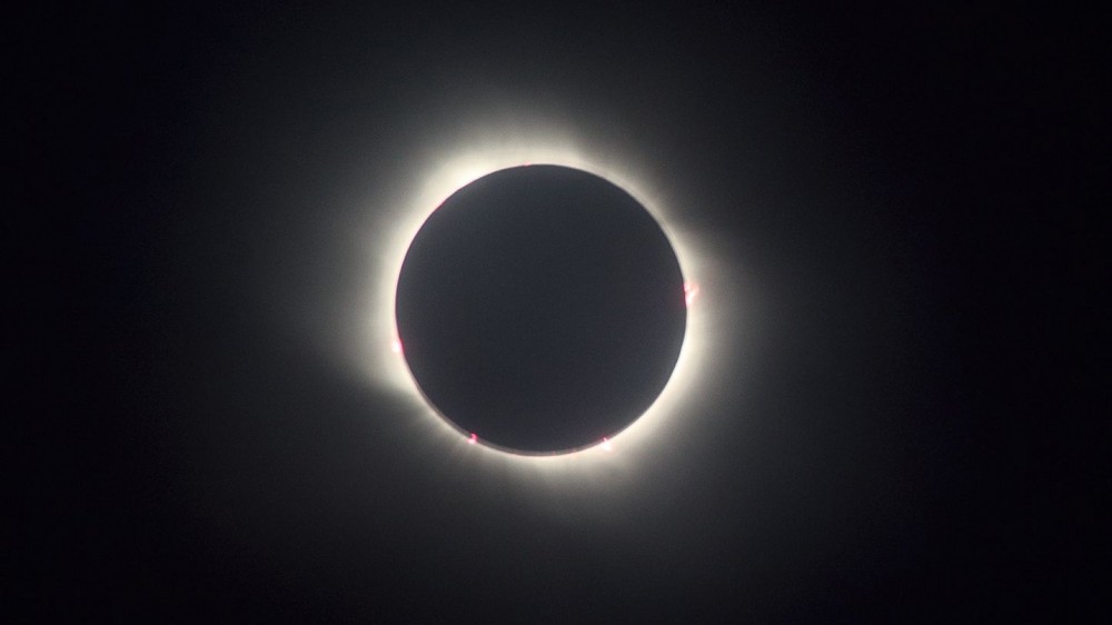 Why do solar eclipses happen?